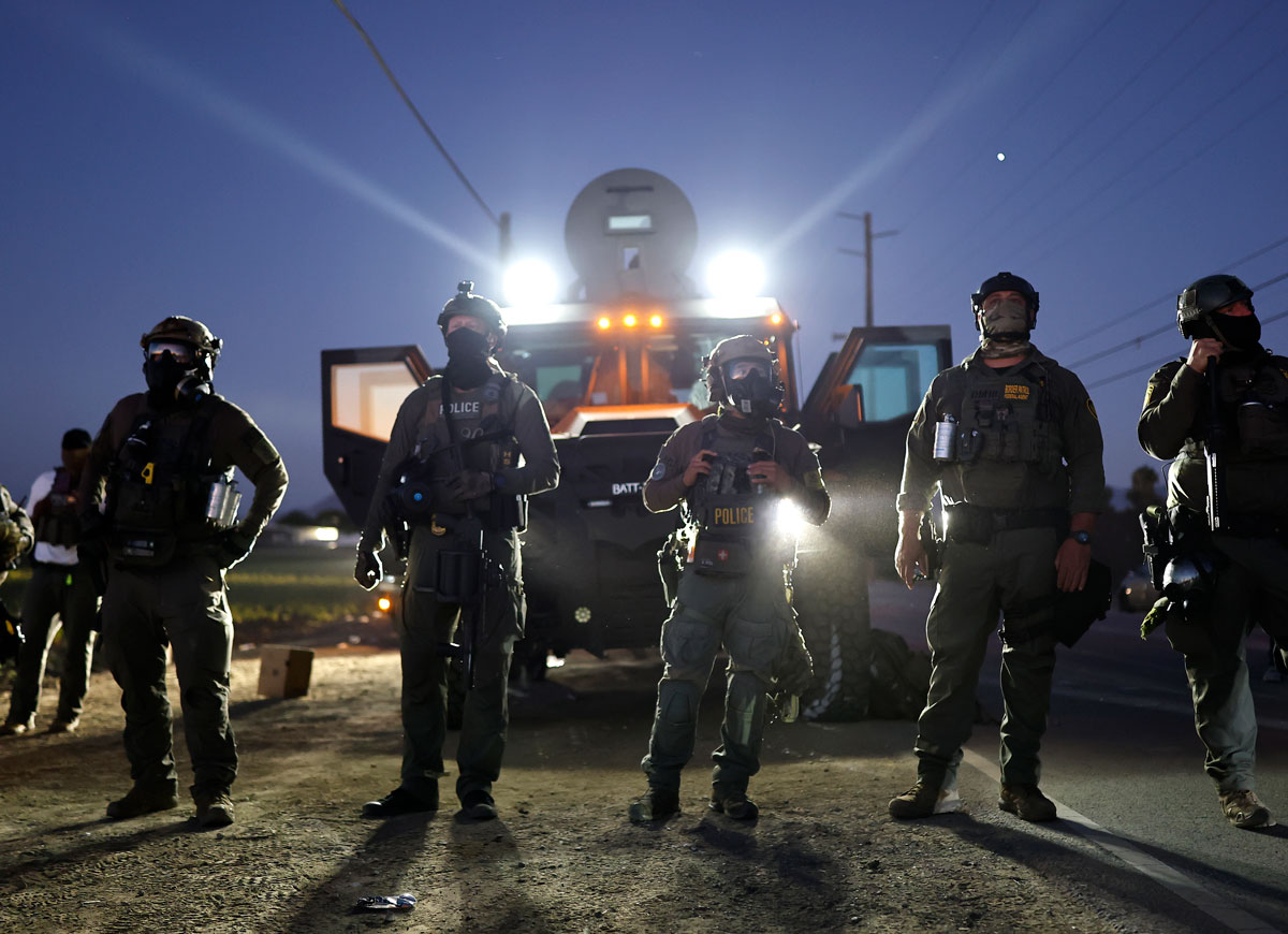 CAMARILLO, CALIFORNIA - JULY 10: Federal agents block people protesting an ICE immigration raid at a nearby licensed cannabis farm on July 10, 2025 near Camarillo, California. Protestors stood off with federal agents for hours outside the farm in the farmworker community in Ventura County. A Los Angeles federal judge is set to rule Friday on a temporary restraining order which would restrict area immigration enforcement operations. (Photo by Mario Tama/Getty Images)