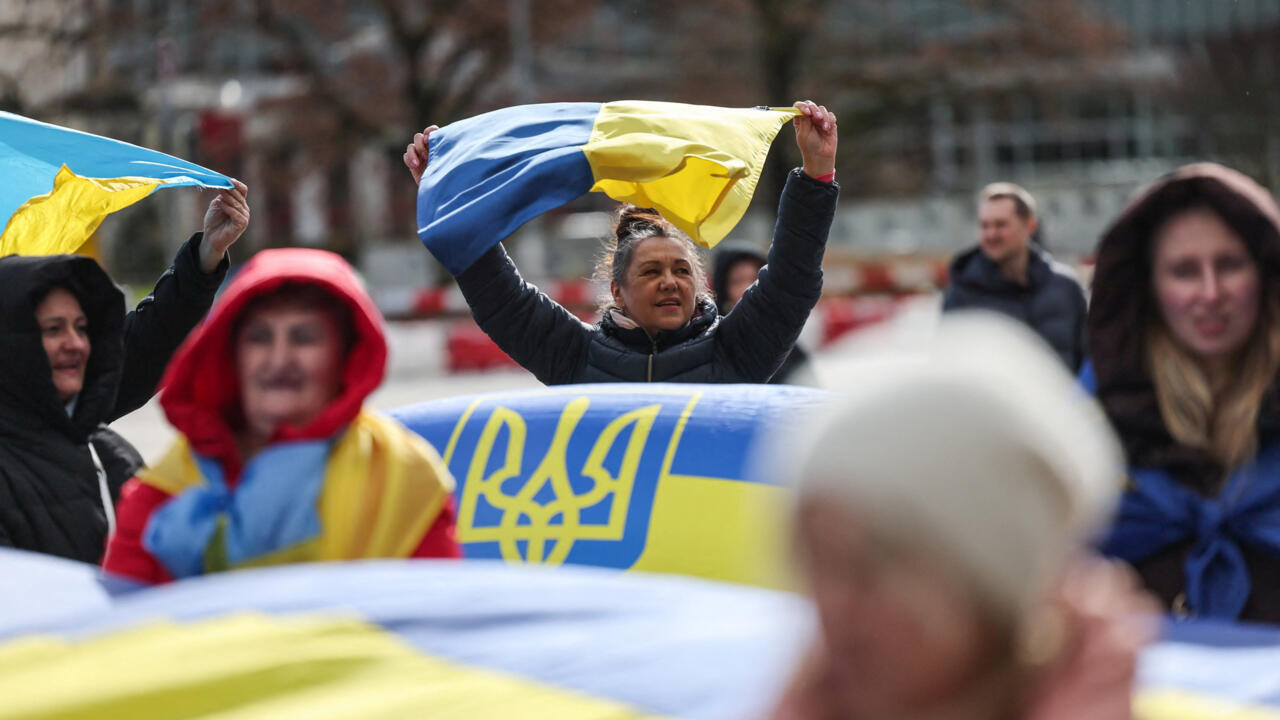 People carry Ukrainian flags at a protest near the United Nations office, on the day of U.S.-mediated peace talks between Russia and Ukraine in Geneva, Switzerland, February 17, 2026.