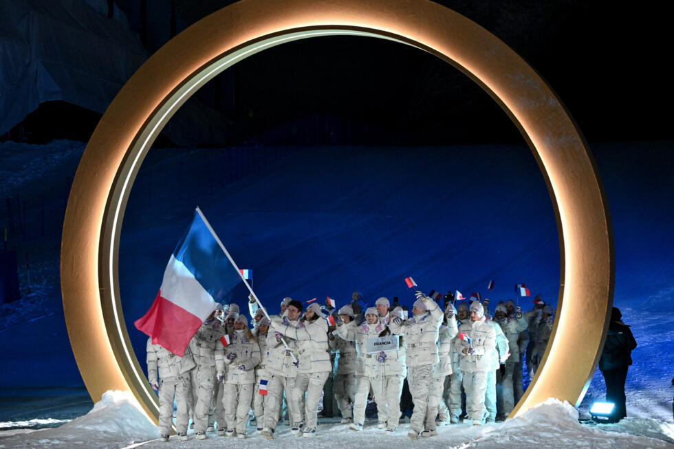 France's flag bearer Clement Noel (C-L) and France's Chloe Trespeuch (C-R) lead the French team in Livigno, northern Italy.