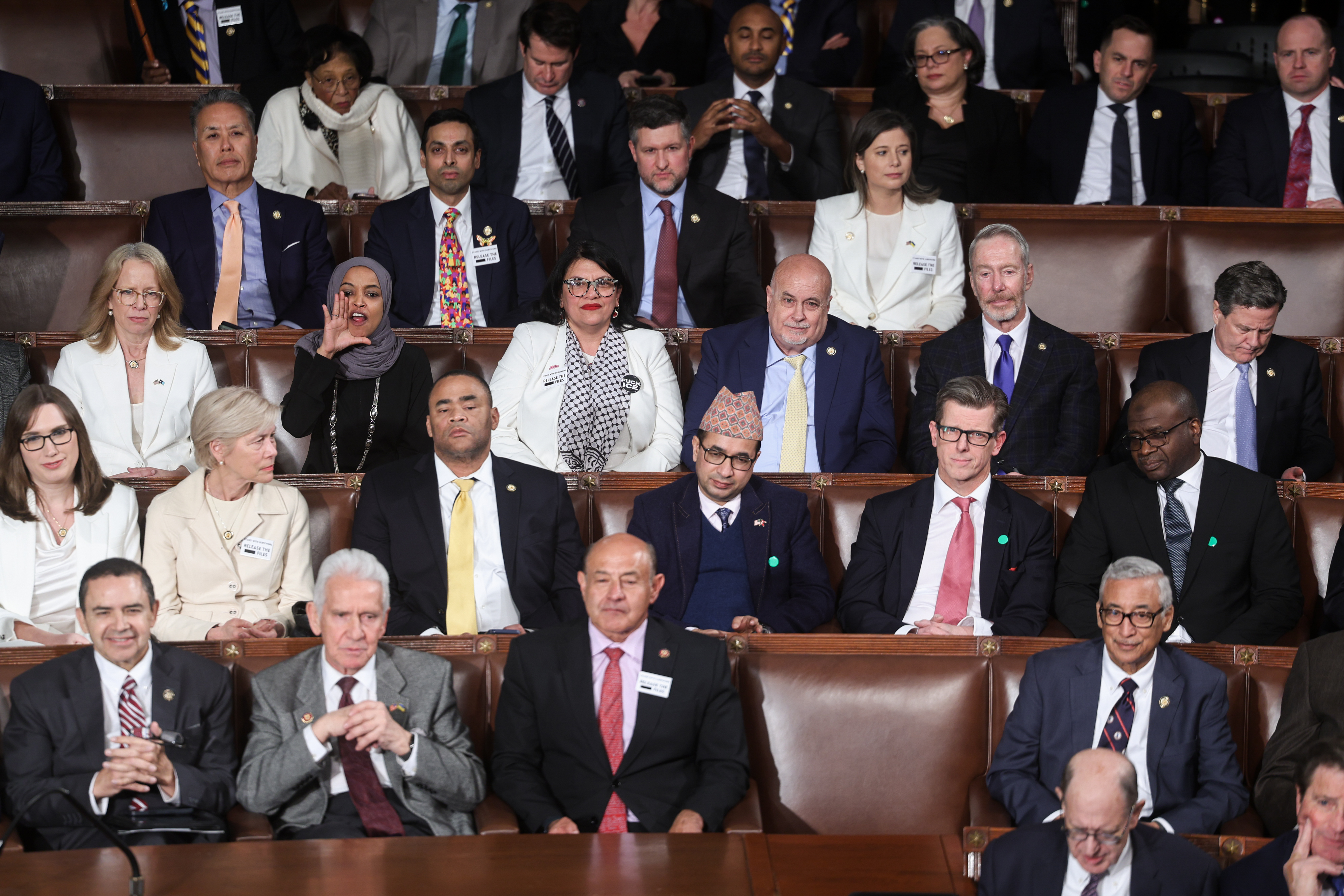 Rep. Ilhan Omar (D-Minn.), center left, reacts as other congressional Democrats look on during Trump's address.