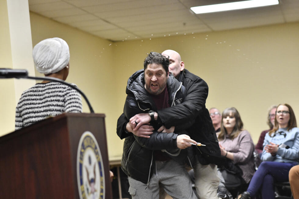 A man is tackled after spraying an unknown substance at US Representative Ilhan Omar during a town hall she was hosting in Minneapolis, Minnesota. 