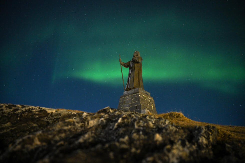 Northern lights glow above a statue of Hans Egede, a Norwegian Lutheran priest and missionary who launched mission efforts to Greenland, in the city of Nuuk, Greenland.