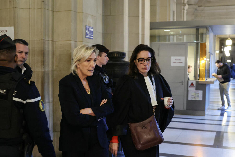 National Rally leader Marine Le Pen walks alongside her lawyer Sandra Chirac Kollarik.