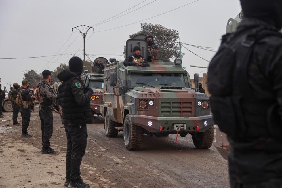 Kurdish-led Syrian Democratic Forces (SDF) combatants welcome the arrival of a convoy of Syria's Interior Ministry security forces.