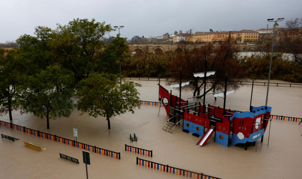 A boat-shaped jungle gym is surrounded by water at a flooded children's playground.
