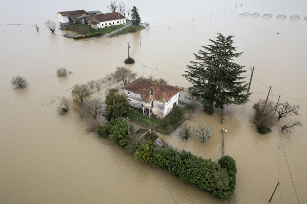 This aerial view shows isolated houses encircled by the floodwaters in the village of Tonneins, France on February 20, 2026