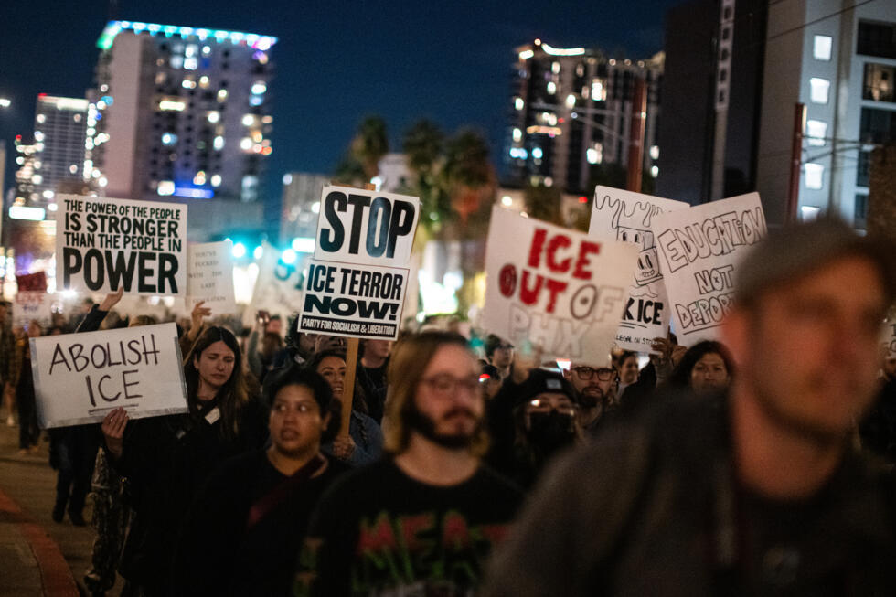 People carry signs and march during a protest against federal immigration enforcement Saturday, Jan. 24, 2026, in Phoenix.