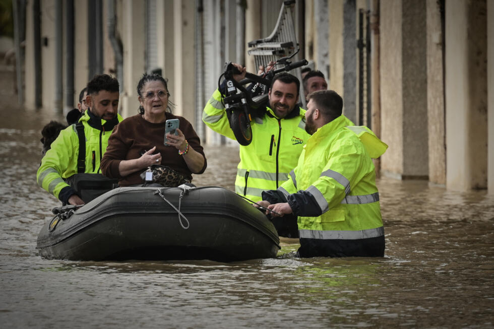 Emergency services evacuate a resident from her home in La Réole, France in an inflatable boat.