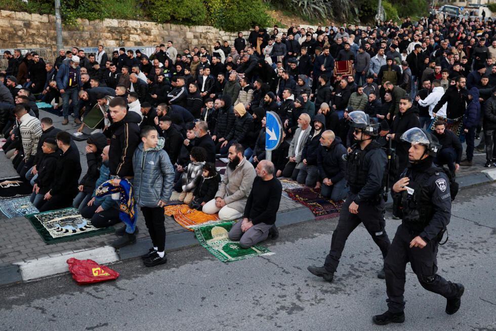 Palestinian Muslim worshippers pray by a road to mark the end of the holy fasting month of Ramadan.