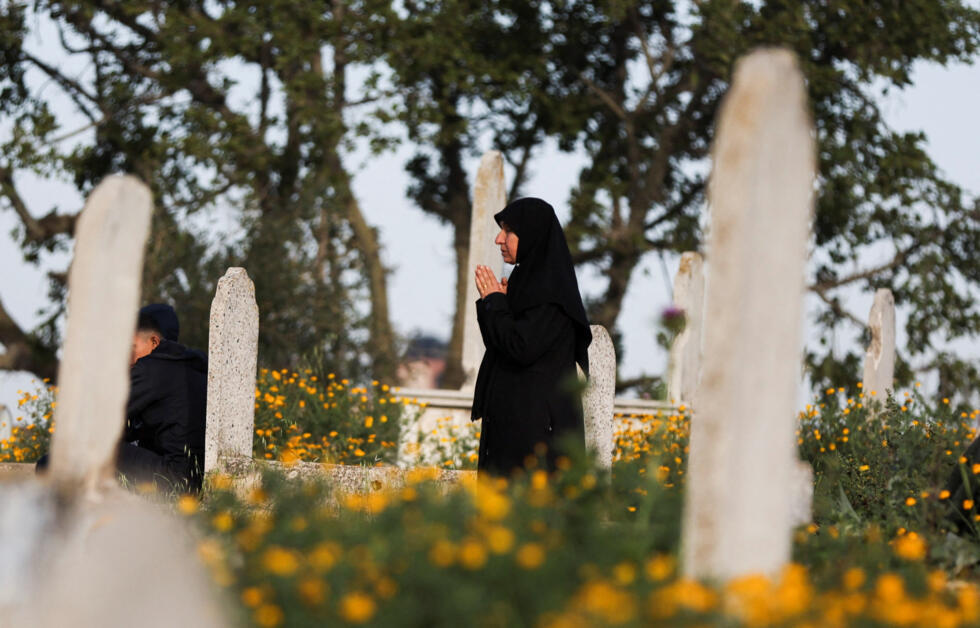 A Palestinian woman visits a grave at a cemetery on Eid al-Fitr, which marks the end of the Muslim holy fasting month of Ramadan, in Gaza City.