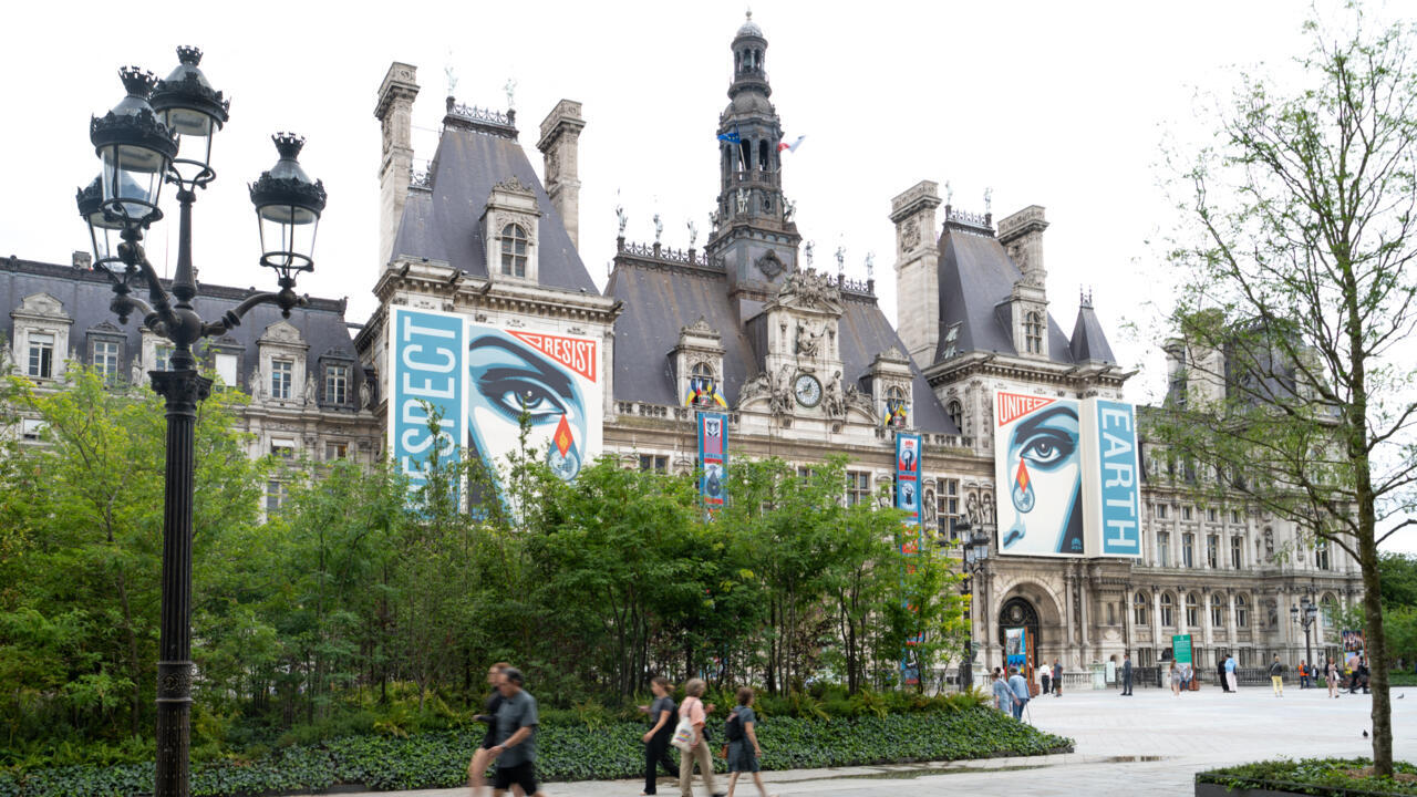 People walk and rest on the Seine River banks in Paris.