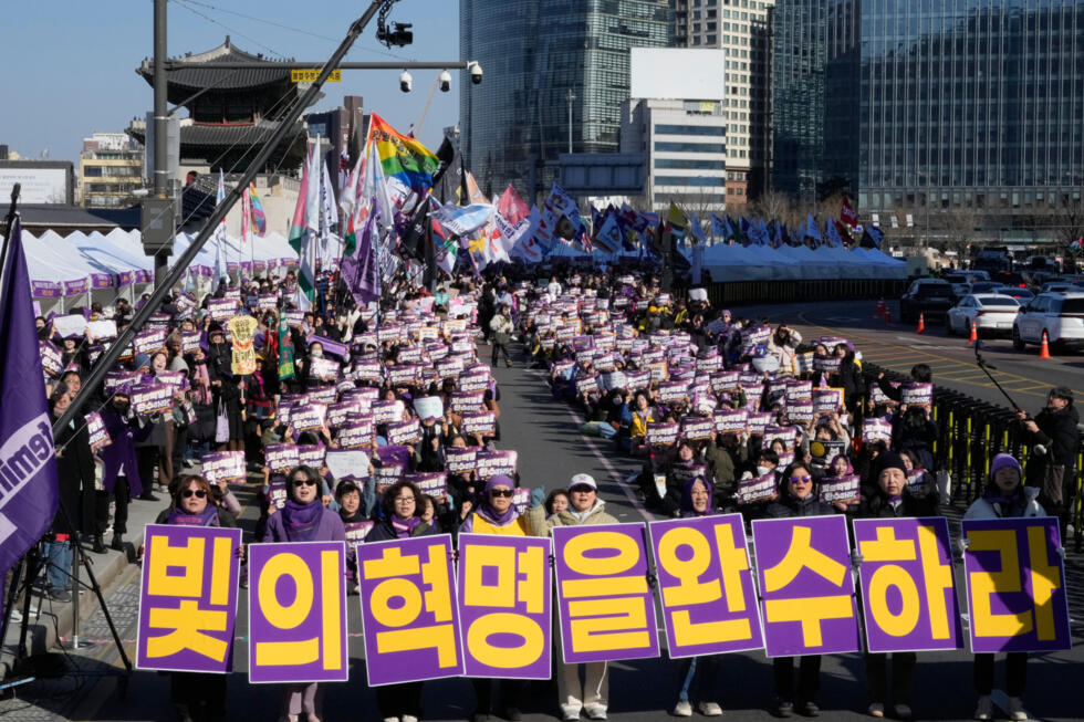 South Korean activists gather a day ahead of International Women's Day in Seoul, South Korea, Saturday, March 7, 2026. The banners read "Complete the revolution of light.
