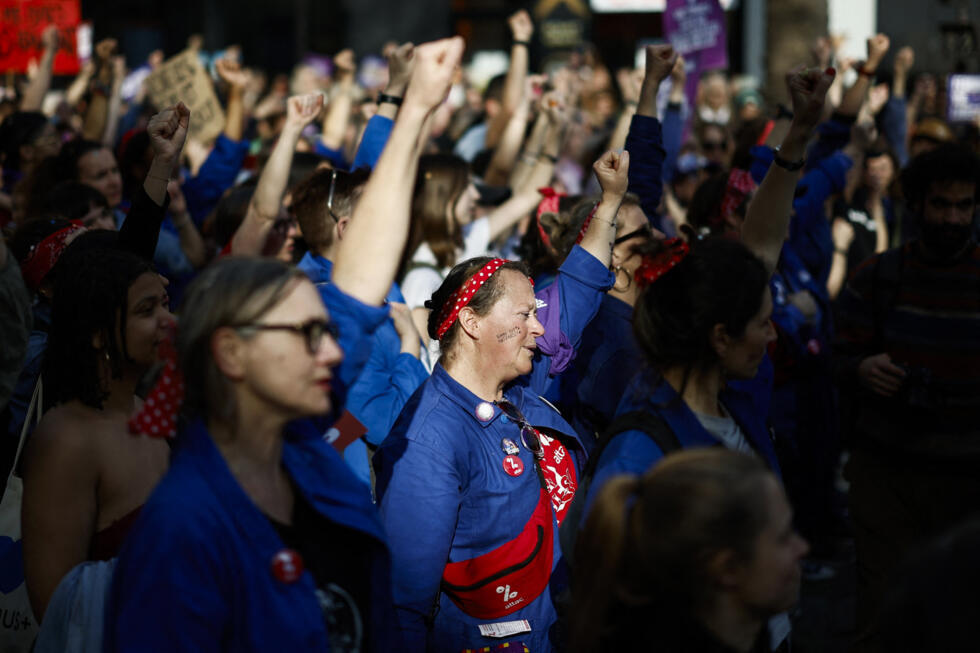 Members of the feminsit collective "Les Rosies" hold their fist in the air during a march marking the International Women's Day in Paris.