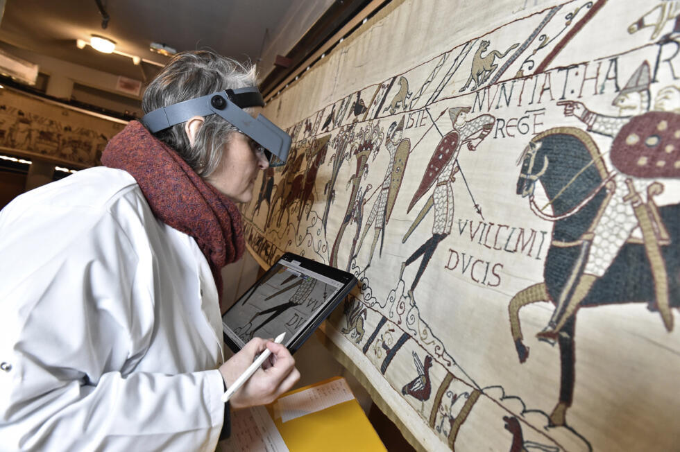 This photo provided by the Ville de Bayeux shows a technician inspecting the tapestry in Bayeux, Normandy.