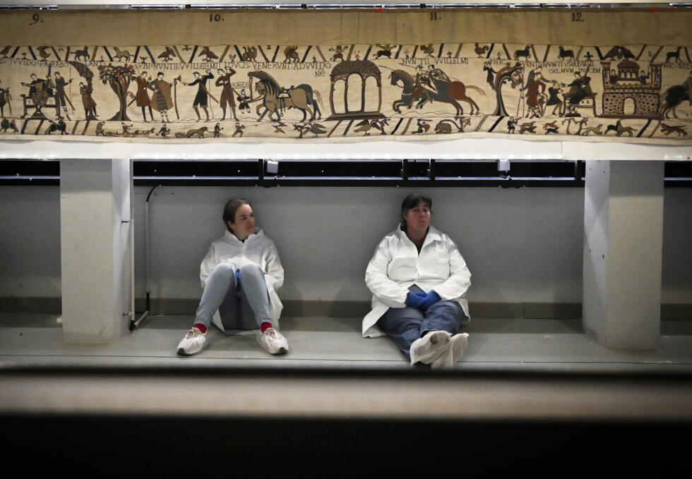 Workers and volunteers rest before preparing to pack the Bayeux Tapestry to transfer to the British Museum, at the Bayeux Tapestry Museum, in Bayeux, northwestern France.
