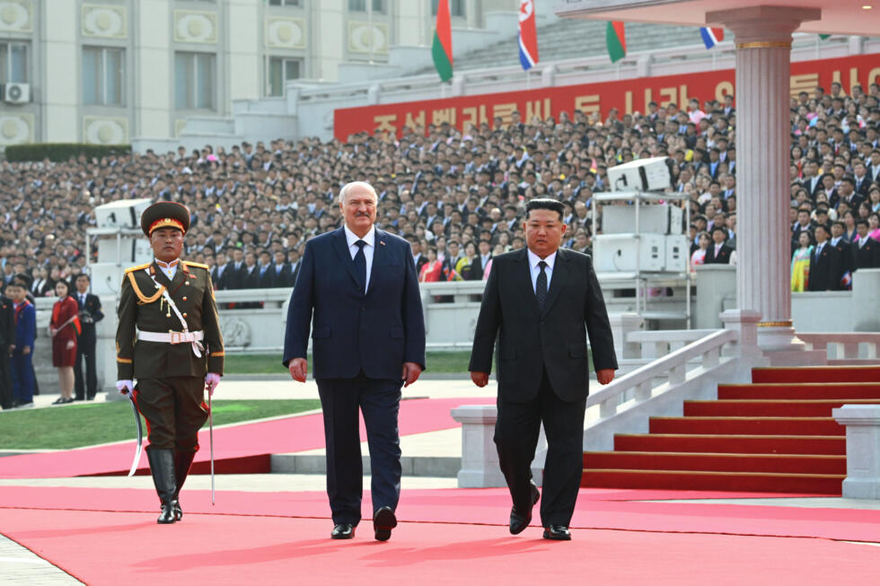 In this photo released by Belarus' Presidential Press Service, North Korea's leader Kim Jong Un, right, and Belarusian President Alexander Lukashenko, center, attend an official meeting ceremony in Py