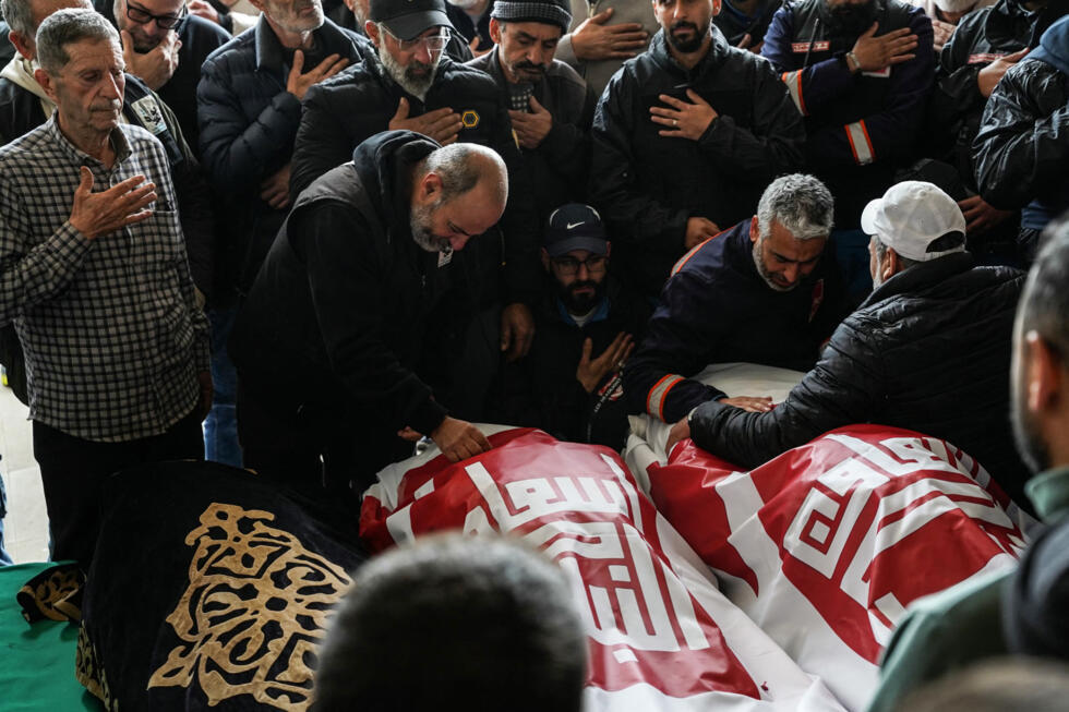 Family members mourn as they take part in the funeral of two first aid responders and a third person the day after they were killed in an Israeli airstrike, in the southern city of Nabatieh.