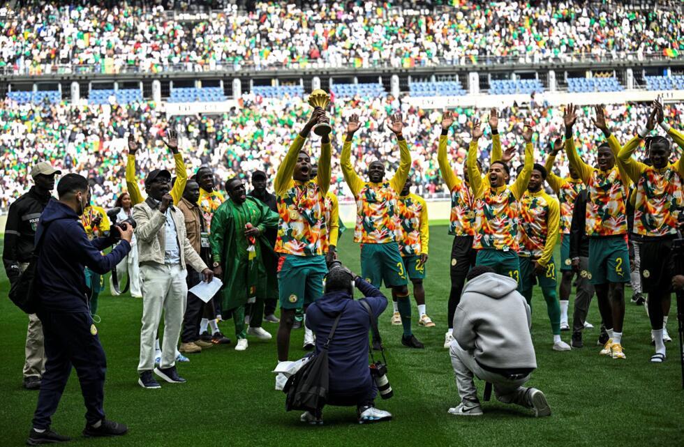 Senegal's players parade with the Africa Cup of Nations trophy ahead of a friendly match at the Stade de France near Paris on March 28, 2026, a week after they were controversially stripped of the tro