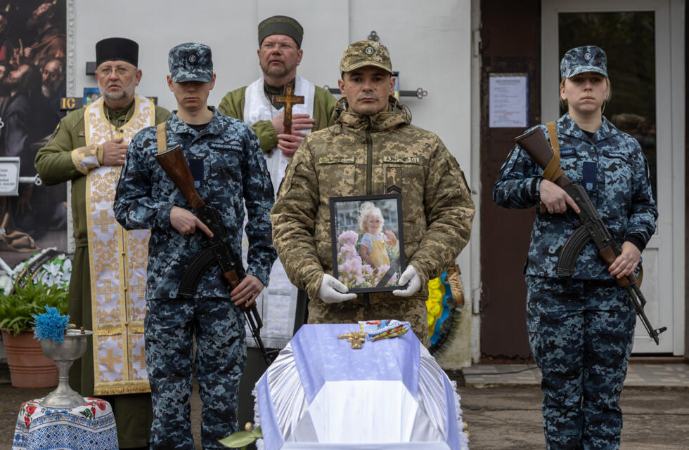 Ukraine soldiers at the funeral of a child killed in a Russian drone attack on a multi-storey residential building in Odesa.