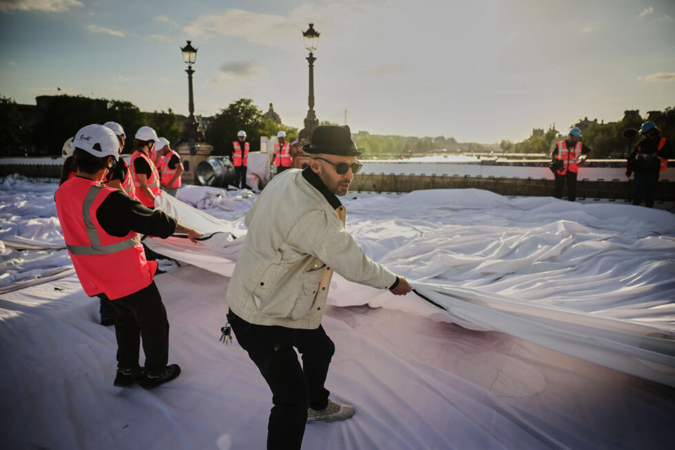 French street artist JR prepares the inflation of his artwork "The Pont Neuf Cave" on Pont Neuf bridge, May 20, 2026, in Paris.