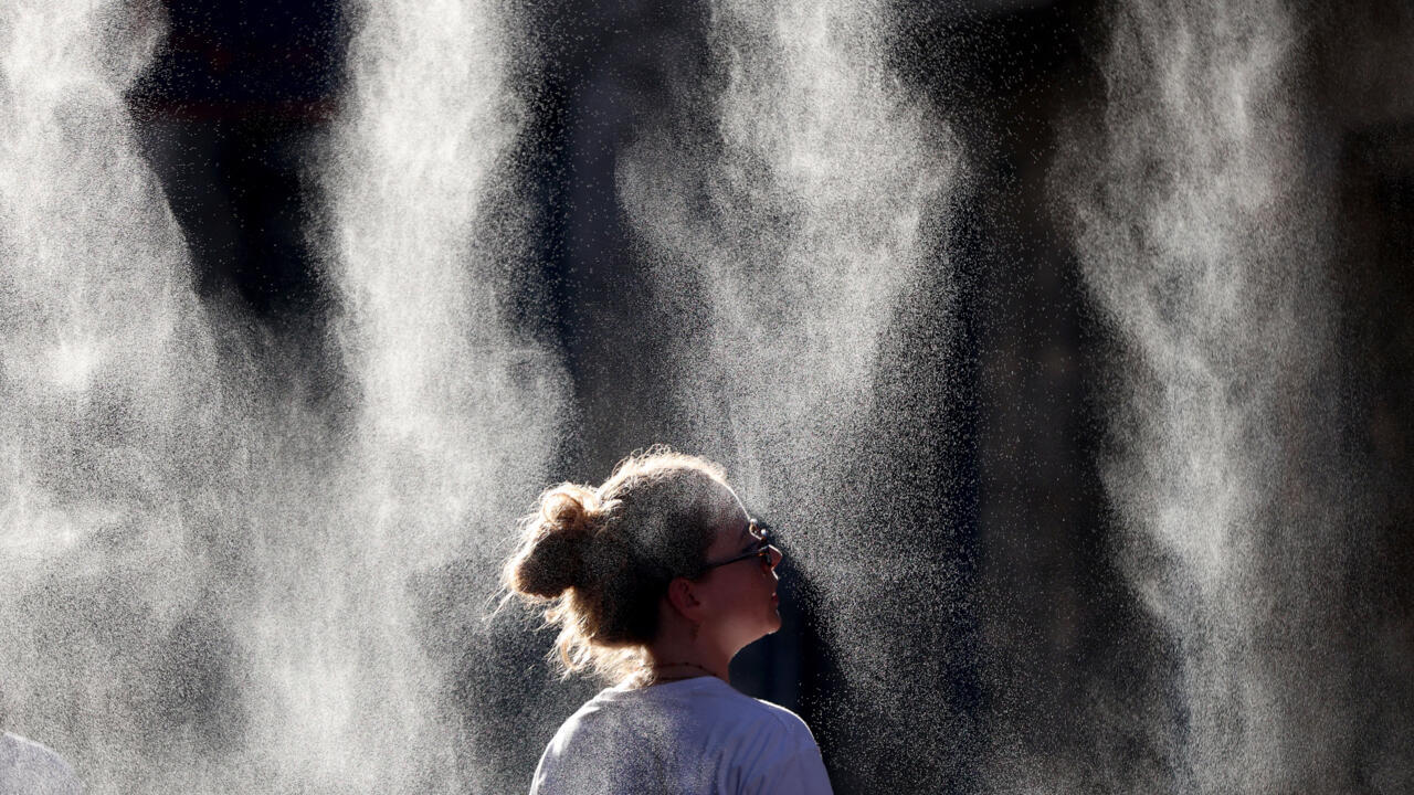Un turista se refresca la cara con agua de una fuente pública situada a las afueras del Coliseo durante una ola de calor en Roma, Italia, el 20 de junio de 2026.