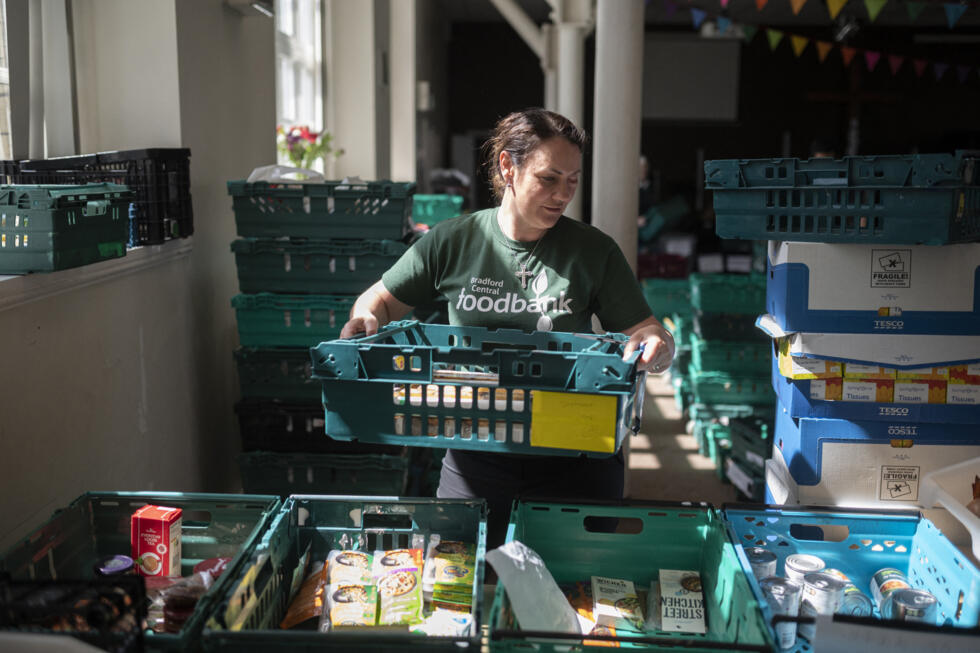 A volunteer puts together food parcels at Bradford Central Foodbank in northern England on May 24, 2022 as a growing number of Britons struggle to buy basics