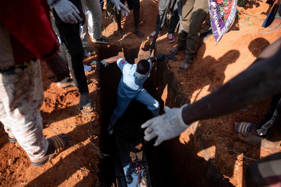 Red Cross volunteers carry out the burial of a person who died from the Ebola virus at the cemetery in Bunia, Ituri Province, Democratic Republic of the Congo, on June 13